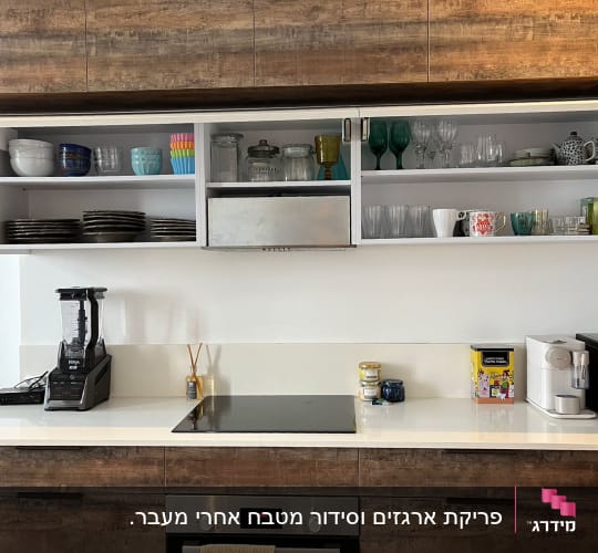 מטבח מאורגן עם מדפים פתוחים, כוסות, צלחות ומכשירי חשמל